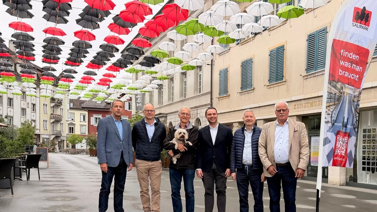 Der Sälipark beschirmt die Oltner Kirchgasse
Das Schirmdach über der Kirchgasse ist zu einem festen saisonalen Bestandteil des Oltner Stadtbildes geworden. Die knapp 500 Regenschirme in vier Farben bilden diesen Sommer eine symbolische Brücke zwischen den beiden Stadtseiten: aussenherum in den Farben des Oltner Logos mit Grün und Weiss, in der Mitte in Rot-Schwarz das stilisierte Logo des Einkaufzentrums Sälipark, das die willkommene Beschattungsaktion finanziell unterstützt. Support bei der Umsetzung leisten wie in den Vorjahren der Werkhof Olten und die Firmen Käser AG und a.en.
Die visuelle Präsenz des Säliparks auf der linken Aareseite setzt ein bewusstes Zeichen: Der Sälipark ist ein Stück Olten und ein attraktiver Partner für die Versorgung der Wohnbevölkerung in und um Olten. Es kann auch als Botschaft verstanden werden, dass die Gewerbetreibenden beider Stadtseiten zusammenarbeiten wollen, um Olten als attraktiven Einkaufsort zu erhalten und zu fördern. 
Foto: Bei der Einweihung des diesjährigen Schirmdachs über der Kirchgasse (vl.): Beat Erne (a.en), Andreas Jäggi (Käser AG), Stadtschreiber Markus Dietler, Alexander Jung (Sälipark/Giroud Olma), Stadtpräsident Thomas Marbet und Klaus Juch (Sälipark).